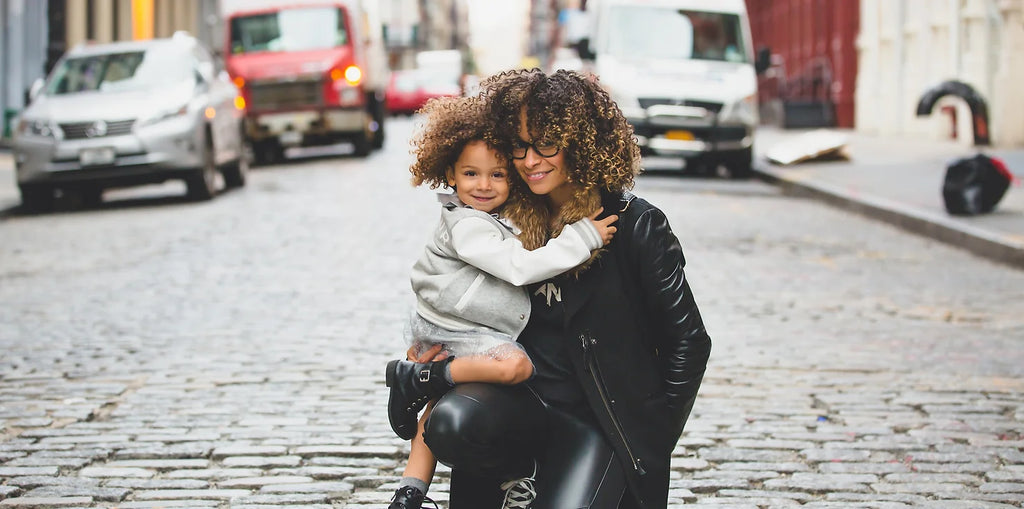 Woman holding young mixed race child on a cobblestoned street